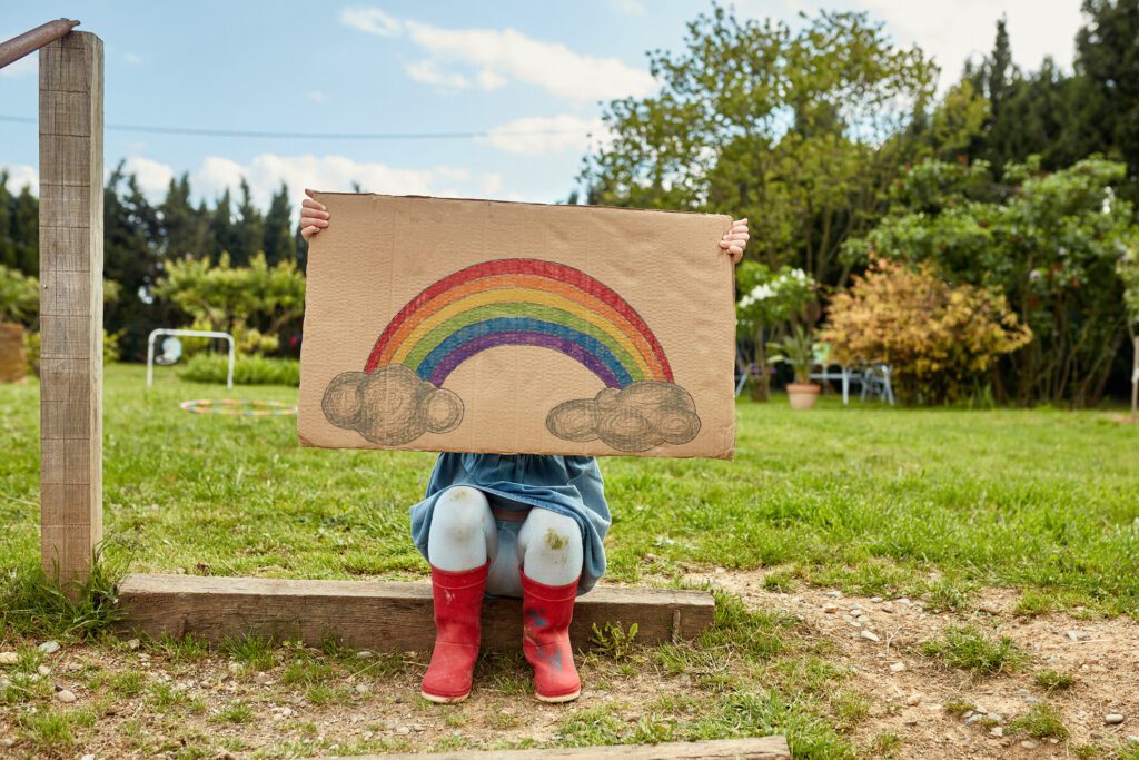 Portrait of Preschool Age Girl Holding Rainbow Sign of Hope