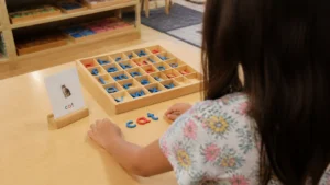 child using the. moveable alphabet